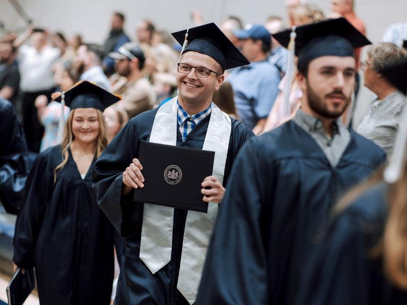 New Penn State graduate Kolton Lyons, who earned an associate degree in business administration, 在<a href='http://7k6.i-conwood.com'>免费mg不朽情缘试玩</a>杜波依斯分校的毕业典礼上，他自豪地向围观的家人和朋友展示自己的学位.